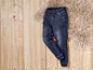 Donkerblauwe jeans met elastiek aan de taille.