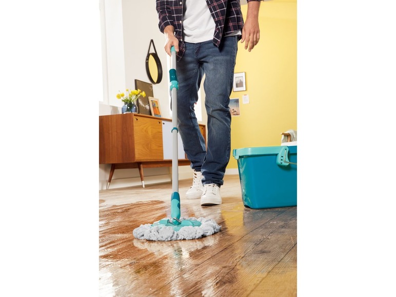 Een persoon die de vloer schoonmaakt met een Vileda mop en emmer.