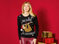 Vrouw draagt een kersttrui met een luiaard en de tekst 'Merry Slothmas'.