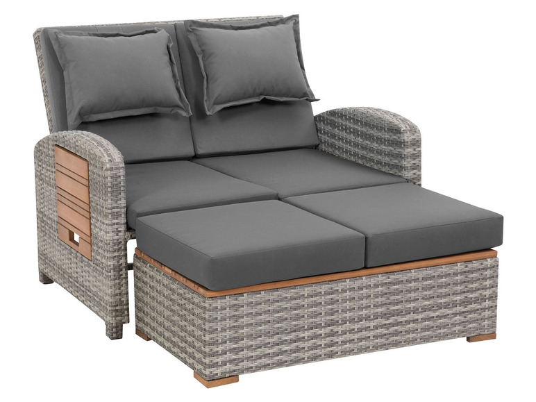 Een grijze wicker loungeset met kussens en een opklapbare voetensteun.