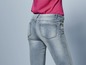 Een vrouw draagt ​​een lichtblauwe jeans.