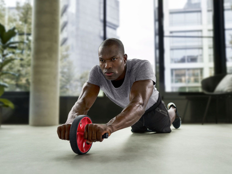 Een man gebruikt een ab-wiel voor een core-workout.