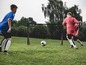 Twee jongens spelen voetbal met een Hudora doel.
