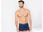 Man draagt donkerblauwe boxershorts met 'Never Stop' opschrift.