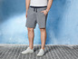 Man draagt grijze jogging shorts en witte sneakers.