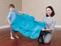 Een vrouw en een jongen spelen met een blauwe luchtmatras.