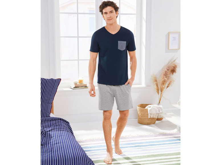 Man draagt een blauwe T-shirt en grijze shorts.