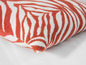 Een kussen met een zebraprint in rood en wit.
