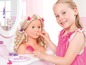 Een meisje speelt met een pop met make-up en haaraccessoires.