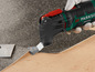Een Parkside PMFW 310 D2 multitool wordt gebruikt om vloerbedekking te verwijderen.