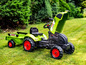 Groene Claas tractor met aanhanger voor kinderen.