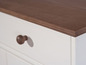 Een wit dressoir met een bruin houten blad.