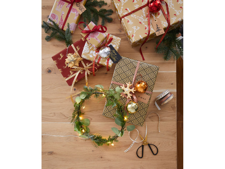 Kerstcadeaus ingepakt met dierenprint, geometrische patronen en kerstversiering.