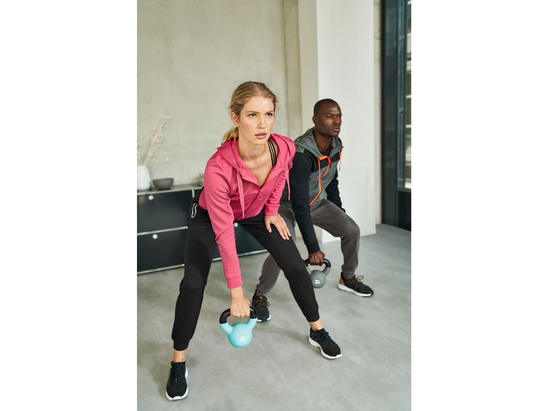 Twee mensen in sportkleding doen een oefening met gewichten.