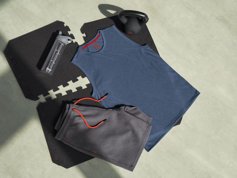 Een blauwe tanktop, grijze broek en een waterfles op een trainingsmat.