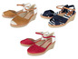 Drie paar espadrilles in bruin, rood en blauw met witte strepen.