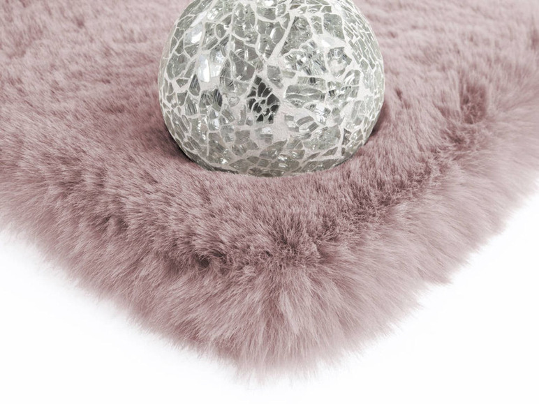 Roze pluche vloerkleed met een glazen decoratie
