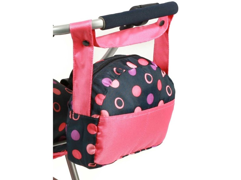 Een roze en zwarte tas met stippen, bevestigd aan een kinderwagen.
