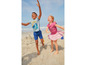 Twee kinderen in zomerkleding spelen op het strand.