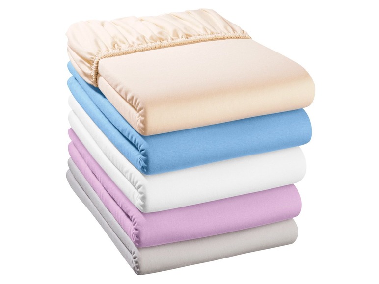 Een stapel bedlakens in verschillende kleuren.