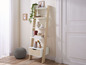 Witte ladderrek met lade, potplanten, decoratieve voorwerpen en boeken.