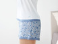 Een witte top en blauwe shorts met bloemenprint.