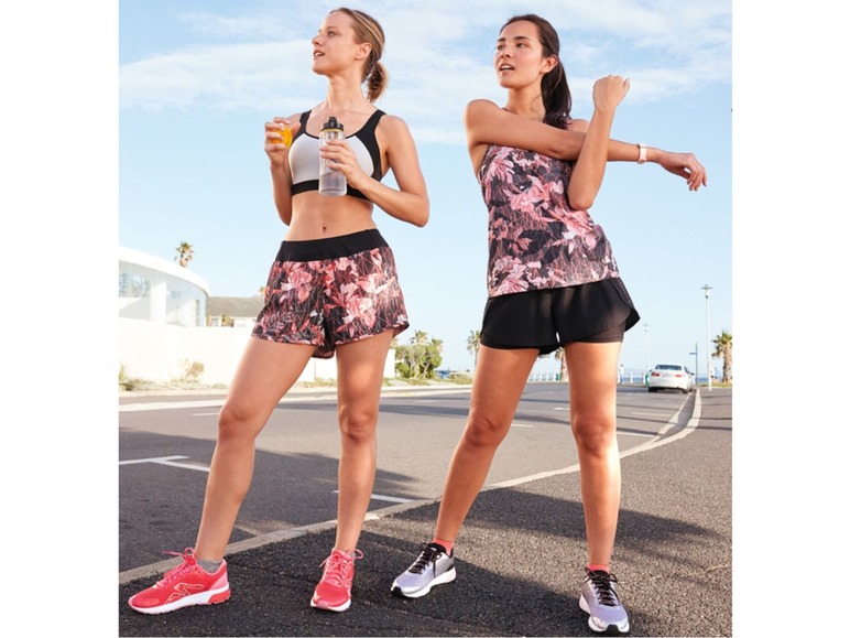 Twee vrouwen in sportkleding met bloemenprint, waaronder shorts en een tanktop.