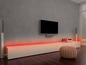 Een tv met luidsprekers en led-verlichting in een moderne woonkamer.