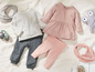 Babykleding met een gestreept roze jurkje, broek en longsleeve.