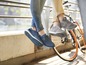 Twee paren blauwe en grijze sneakers met een fiets op de achtergrond.