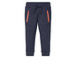 Blauwe joggingbroek met oranje ritsen.