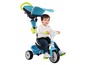 Een kind dat op een blauwe Smooby Baby-trike rijdt.