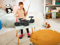 Een meisje speelt op een elektronische drumset in een kinderkamer.