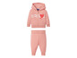 Een roze hoodie en joggingbroek met hartjesprint.