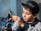 Een jongen houdt een LEGO Technic voertuig vast.
