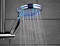 Een moderne douchekop met blauwe ledverlichting en waterstralen.