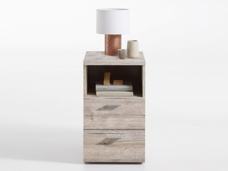 Nachtkastje met twee laden, een open vak en een lamp.