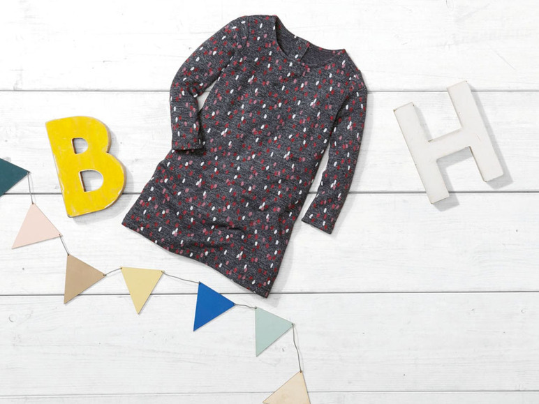 Een grijs jurkje met stippen, een vlaggenlijn en de letters B en H.