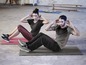 Man en vrouw doen sit-ups op fitnessmatten.