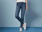 Een vrouw die blauwe skinny jeans draagt met witte sneakers.