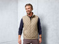 Man draagt een beige gewatteerd vest.