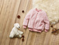 Een roze fleece jack met een wit knuffelbeest.