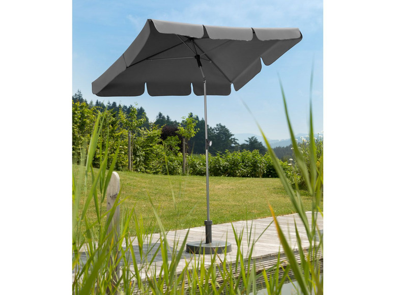 Een grijze parasol voor de tuin, op een houten terras.