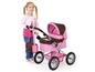 Een meisje speelt met een roze kinderwagen.
