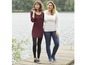 Twee vrouwen dragen casual kleding, waaronder een lange donkerrode jurk, een wit T-shirt en jeans.