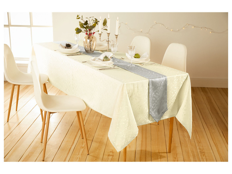 Een witte tafel met een grijs tafelkleed en witte stoelen.