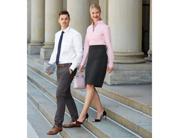 Man en vrouw in zakelijke kleding op een trap.