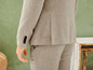 Een beige linnen pak met een jasje en broek.