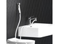 Een bidet sproeikop en wastafel in een moderne badkamer.