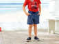 Een jongen draagt een rood T-shirt met een motorprint en blauwe shorts met een motorprint.